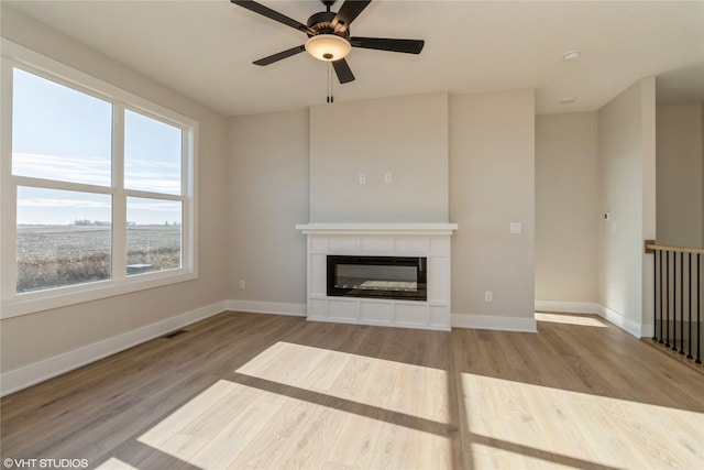 unfurnished living room featuring ceiling fan and light hardwood / wood-style floors