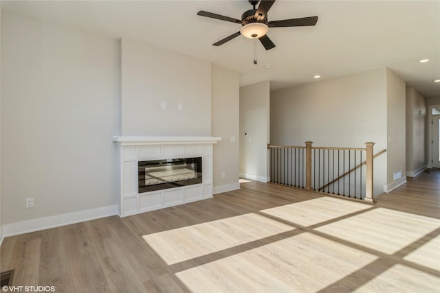 unfurnished living room with light hardwood / wood-style flooring and ceiling fan