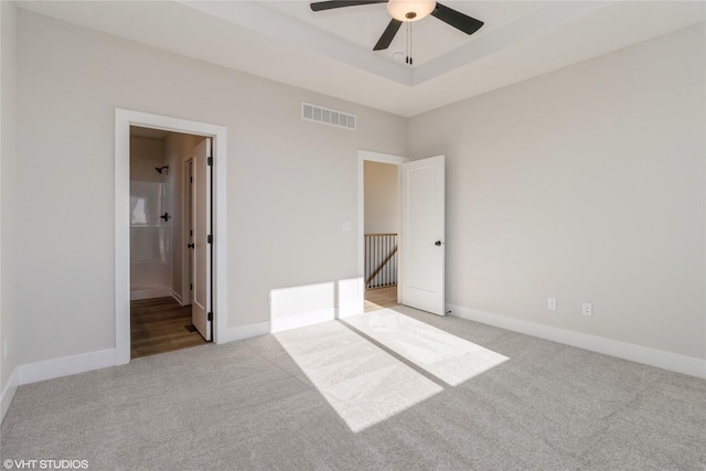 unfurnished bedroom with ensuite bathroom, ceiling fan, and light carpet