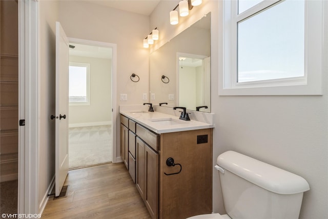 bathroom with toilet, vanity, and hardwood / wood-style flooring