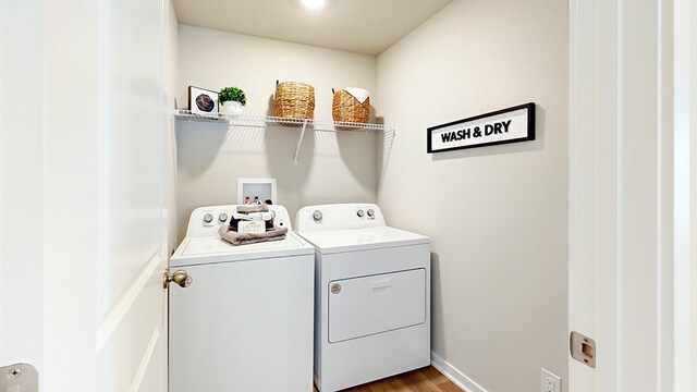 clothes washing area featuring separate washer and dryer and hardwood / wood-style floors