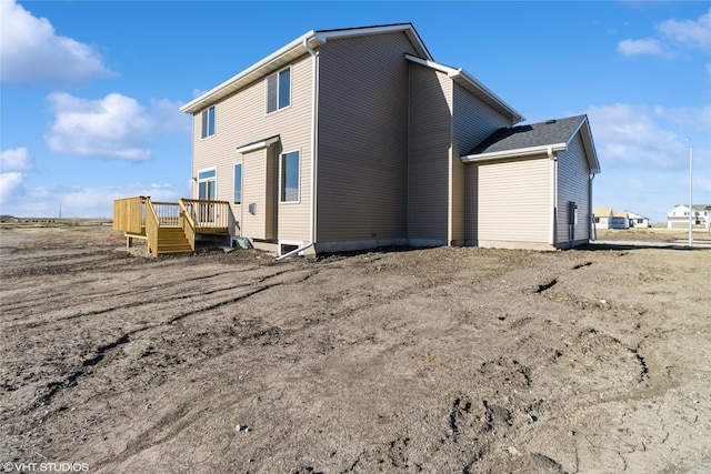 rear view of house featuring a wooden deck