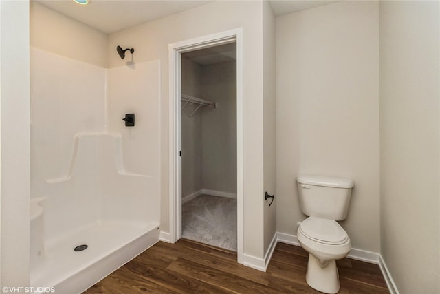 bathroom featuring toilet, wood-type flooring, and walk in shower