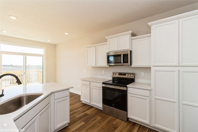 kitchen featuring sink, white cabinetry, dark hardwood / wood-style flooring, and stainless steel appliances