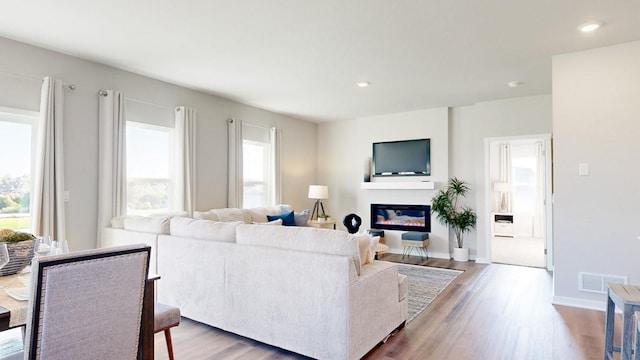 419 Creekview Ave, Polk City, IA 50226 - living room with visible vents, baseboards, a glass covered fireplace, and wood finished floors