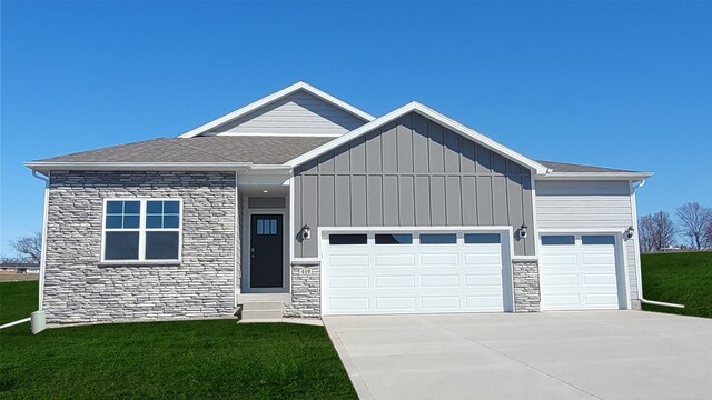 419 Creekview Ave, Polk City, IA 50226 - view of front of home with board and batten siding, stone siding, a front lawn, a garage, and concrete driveway