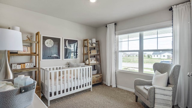 carpeted bedroom with a nursery area