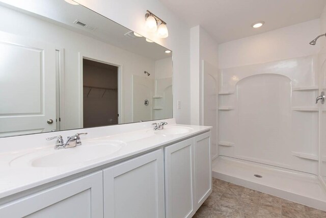 bathroom with a shower and vanity