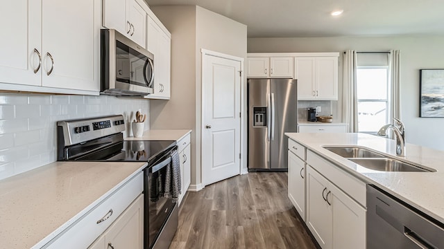 kitchen featuring white cabinets, wood-type flooring, sink, and appliances with stainless steel finishes