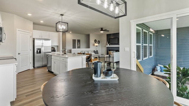 dining area featuring wood-type flooring, ceiling fan, and sink