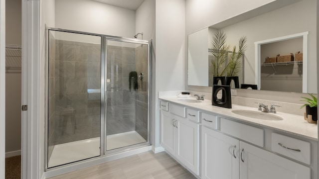 bathroom with vanity, a shower with shower door, and hardwood / wood-style flooring