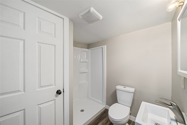 bathroom featuring walk in shower, wood-type flooring, toilet, and sink