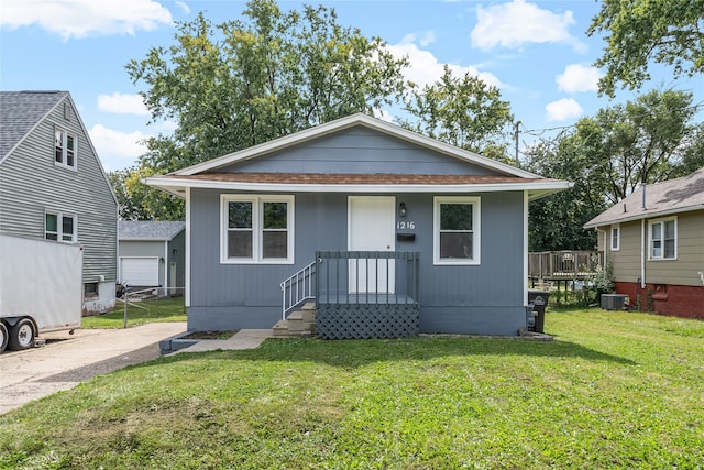 bungalow-style home featuring a front lawn and central AC unit