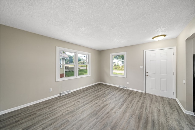 interior space featuring a textured ceiling and light hardwood / wood-style flooring