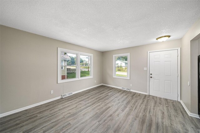 interior space with wood finished floors, baseboards, and visible vents