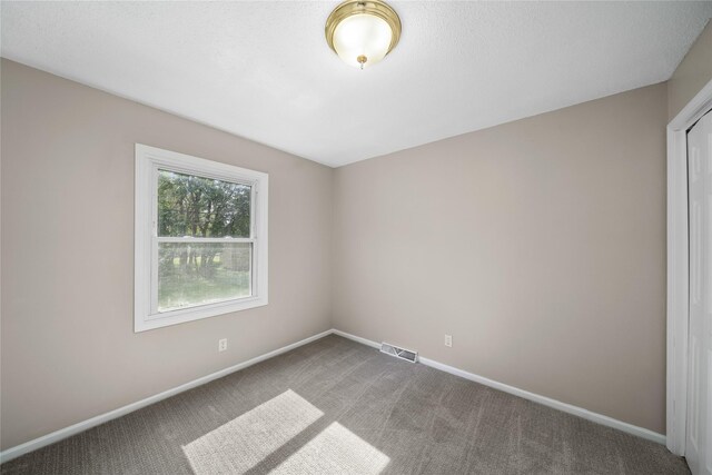 spare room with baseboards, visible vents, and carpet