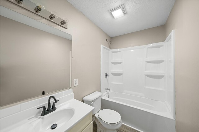 bathroom with tub / shower combination, a textured ceiling, visible vents, toilet, and vanity