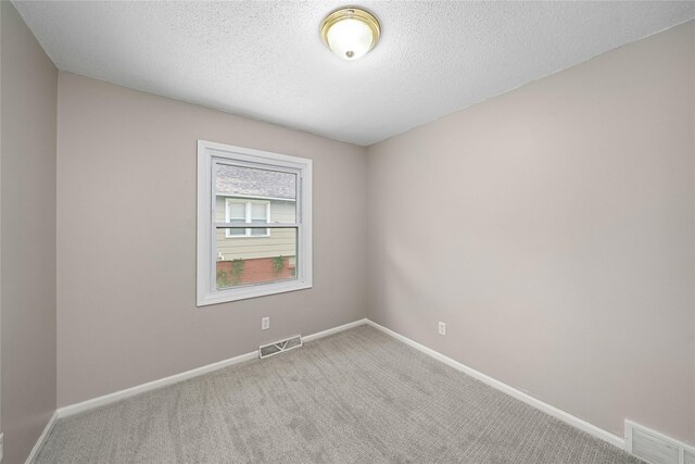spare room featuring baseboards, carpet floors, and visible vents