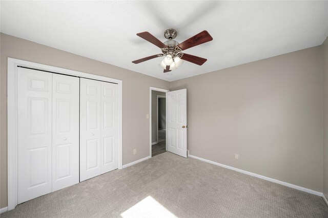 unfurnished bedroom with baseboards, a closet, carpet, and a ceiling fan