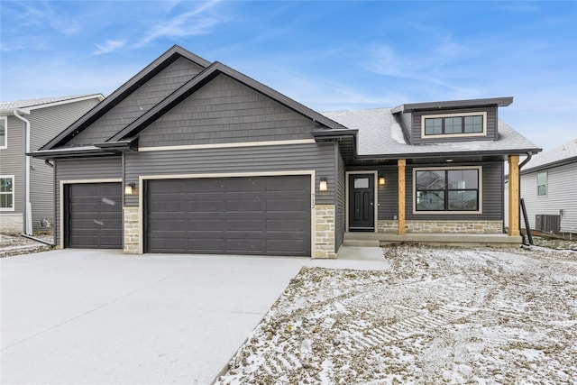 view of front of property featuring a porch, a garage, and central air condition unit