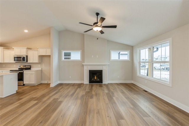 unfurnished living room featuring ceiling fan, light hardwood / wood-style floors, and lofted ceiling