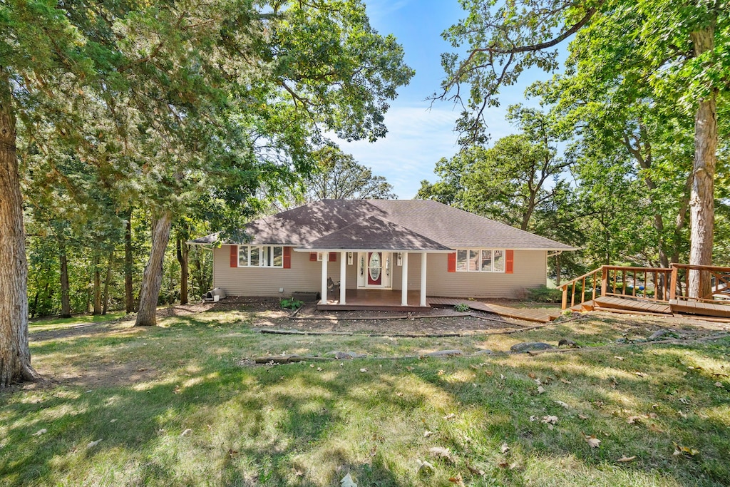 ranch-style house with a front yard and a deck