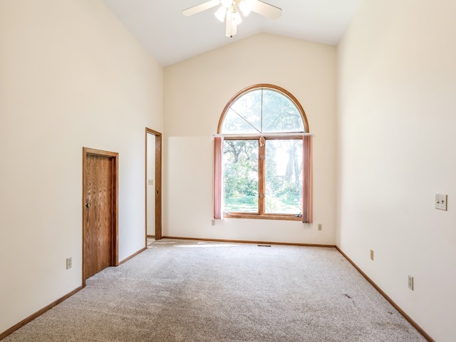 empty room featuring lofted ceiling, ceiling fan, and light colored carpet