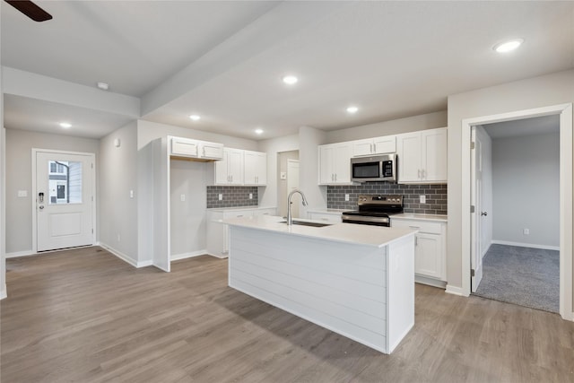 kitchen featuring white cabinetry, appliances with stainless steel finishes, sink, and a center island with sink