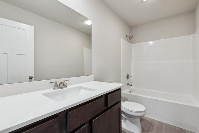 full bathroom with shower / tub combination, vanity, wood-type flooring, and toilet