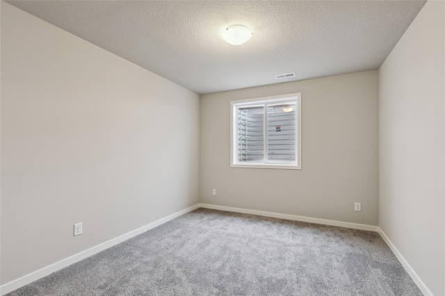 carpeted spare room featuring a textured ceiling