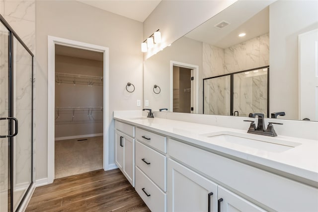 bathroom featuring vanity, wood-type flooring, and a shower with door