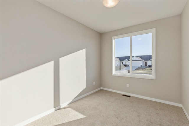 spare room featuring light carpet