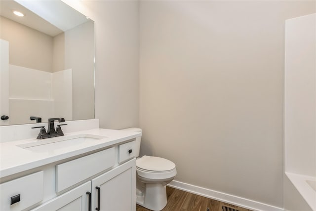 bathroom featuring vanity, hardwood / wood-style flooring, and toilet