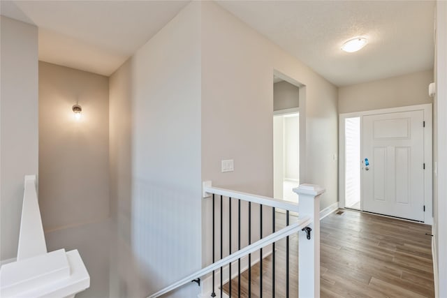 entryway with wood-type flooring and a textured ceiling