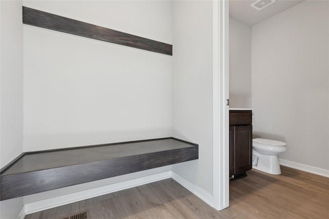 bathroom featuring hardwood / wood-style flooring, toilet, and vanity