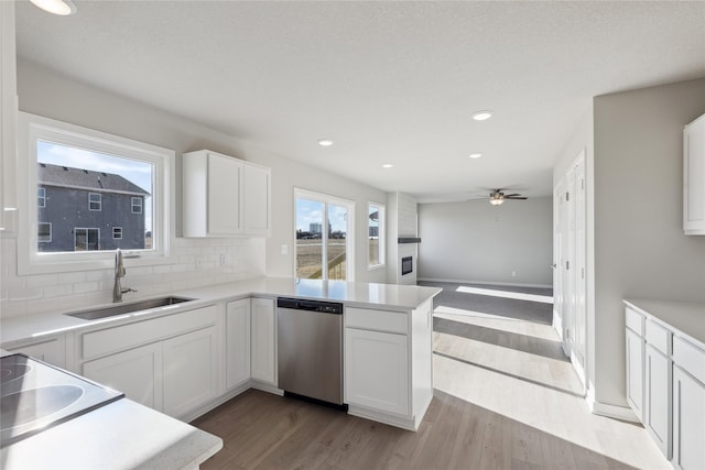 kitchen featuring dishwasher, white cabinetry, tasteful backsplash, sink, and light wood-type flooring