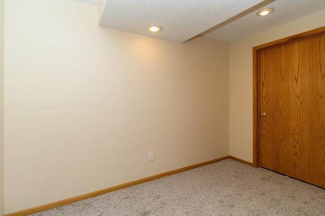 spare room with light colored carpet and baseboards