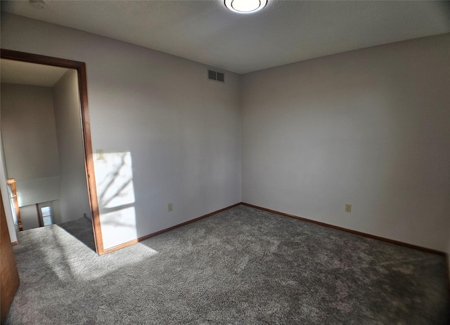 carpeted spare room featuring visible vents and baseboards