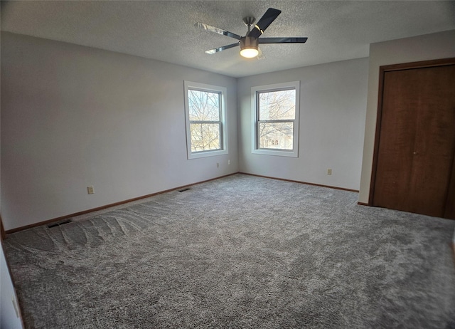 unfurnished bedroom with visible vents, a ceiling fan, a textured ceiling, carpet floors, and baseboards