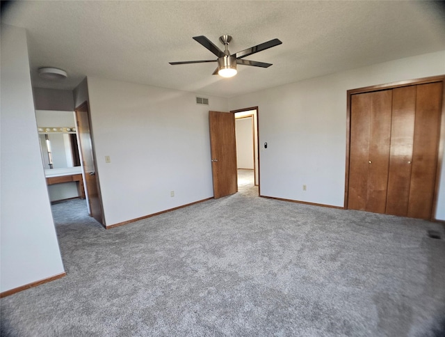 unfurnished bedroom with baseboards, visible vents, a closet, a textured ceiling, and carpet flooring