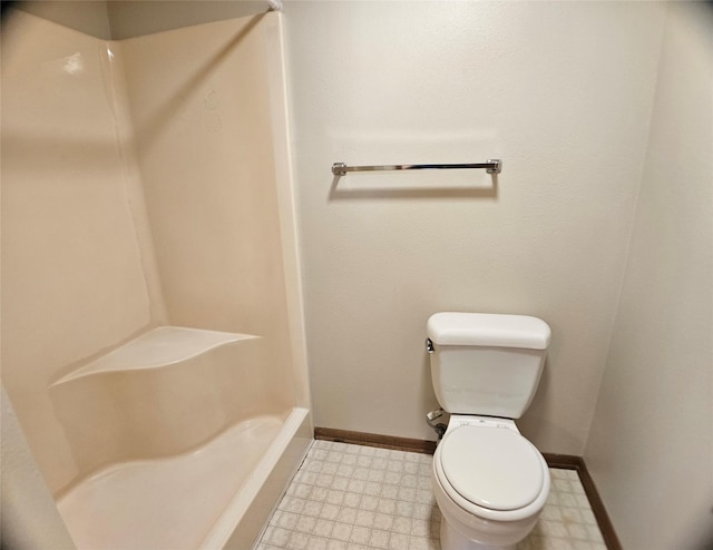 bathroom featuring tile patterned floors, toilet, a shower, and baseboards