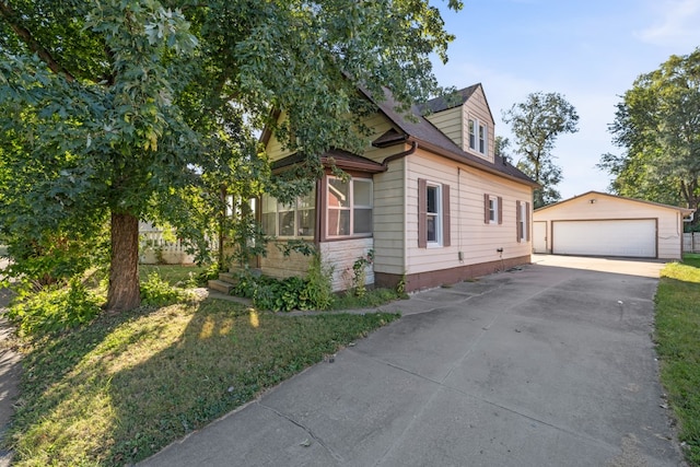 view of front of home featuring a front yard, a garage, and an outdoor structure