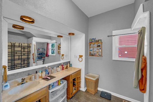 2329 Maple St, Des Moines, IA 50317 - full bathroom featuring double vanity, baseboards, plenty of natural light, and a shower