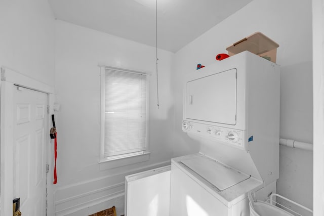 clothes washing area featuring stacked washing maching and dryer