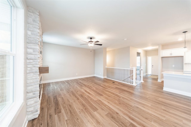 unfurnished living room featuring ceiling fan and light wood-type flooring