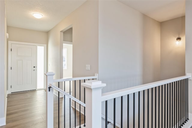 hallway with light hardwood / wood-style flooring and a textured ceiling