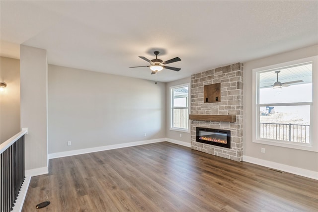 unfurnished living room featuring ceiling fan, dark hardwood / wood-style flooring, and a fireplace