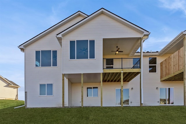 back of property featuring ceiling fan, a balcony, and a yard