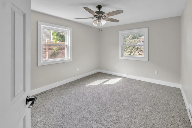 carpeted spare room featuring visible vents, a ceiling fan, and baseboards