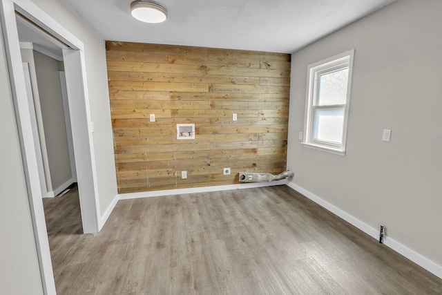 laundry area featuring wood walls, washer hookup, wood finished floors, and hookup for an electric dryer